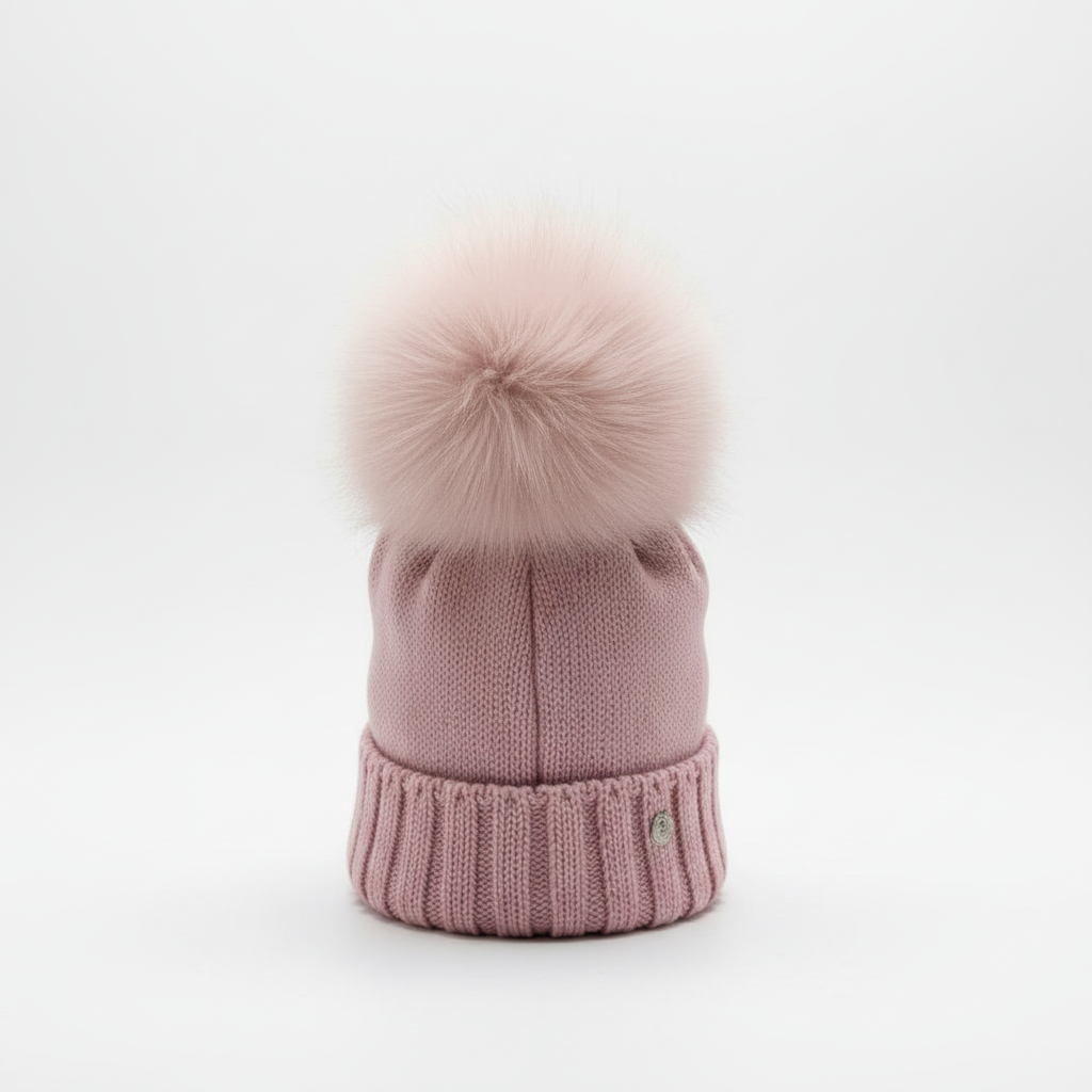 Cappello rosa antico con pon-pon su sfondo bianco